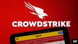 Logo konpayi CrowdStrike ak yon paj entenet Spirit Airlines sou ekran yon odinate ak telefon entelijan nan Nouyok, 19 Jiye, 2024.