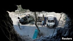 Local residents inspect cars destroyed by recent shelling in the course of Ukraine-Russia conflict in the Russian-controlled city of Enerhodar in Zaporizhzhia region, Ukraine, Aug. 30, 2022. 