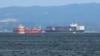 FILE - In this Saturday, June 17, 2017, photo, the damaged Philippine-registered container ship ACX Crystal, right, cruises past another container ship off Yokosuka, south of Tokyo, after colliding with the USS Fitzgerald off Japan earlier in the day, tha